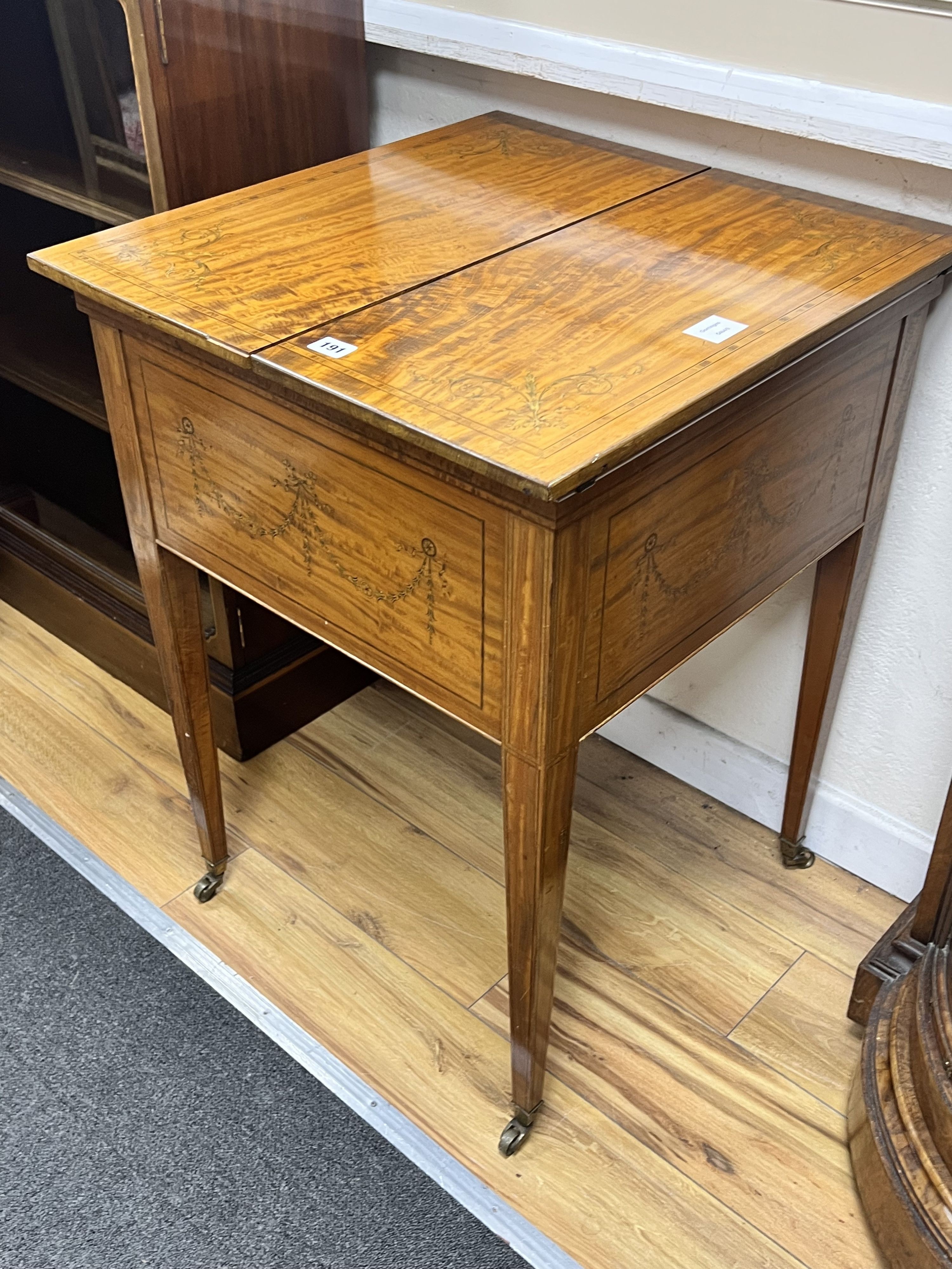 An Edwardian banded satinwood mahogany surprise drinks cabinet by Maple & Co, banded in kingwood and inlaid with husk festoons, divided opening top with rising interior, circa 1900., width 56cm depth 59cm height 78cm